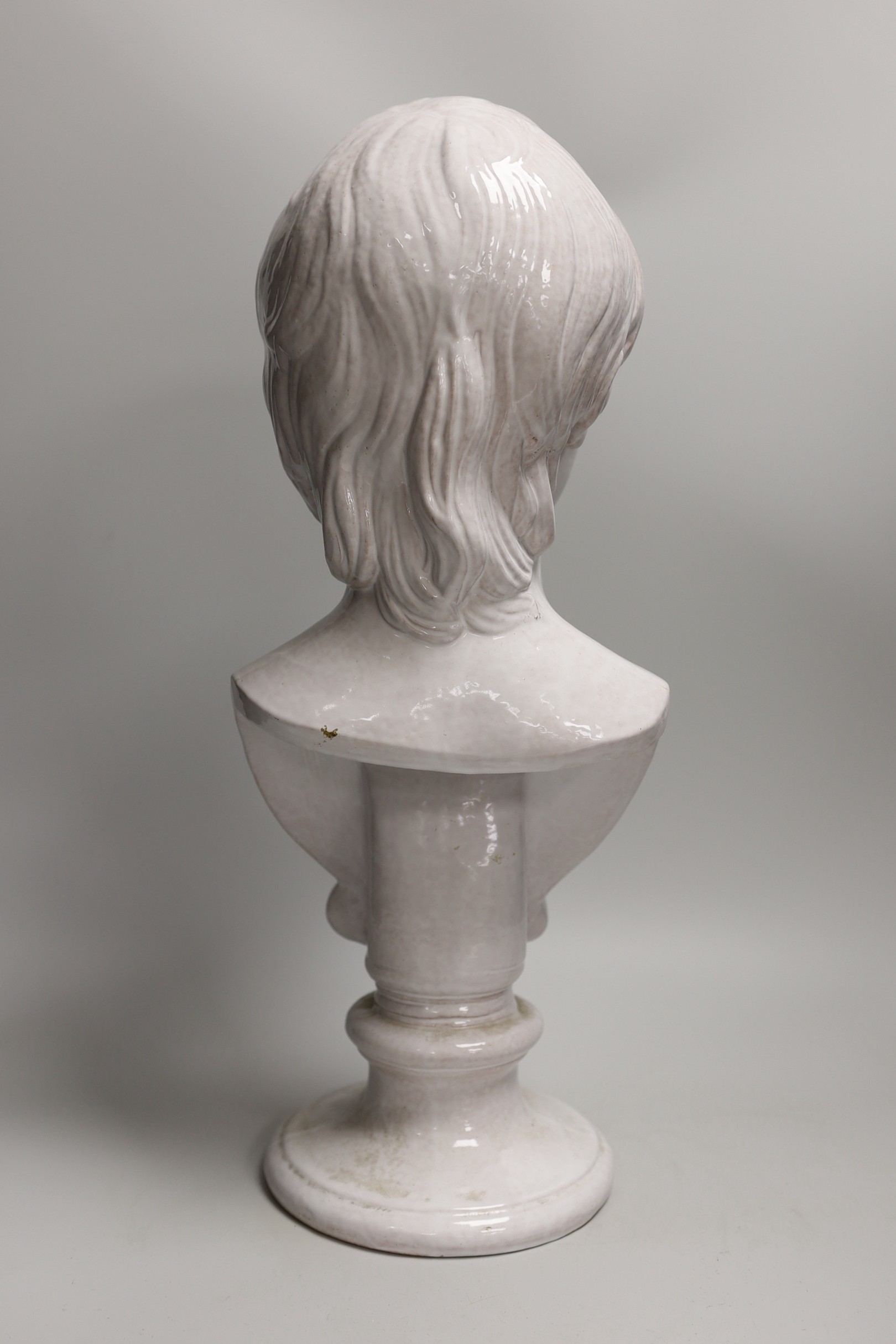 A Continental tin glazed terracotta bust of a boy, 47cm tall